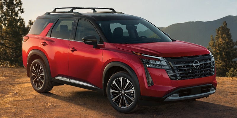 2026 Nissan Pathfinder red SUV parked outdoors with mountain backdrop